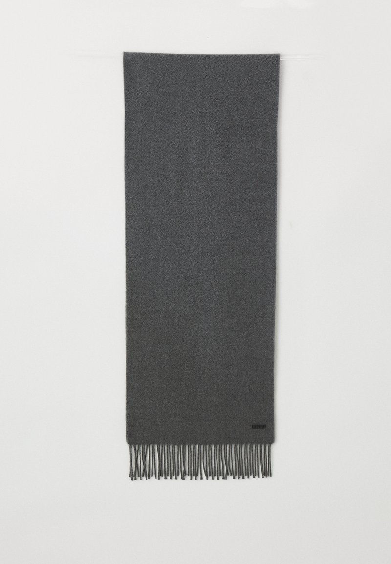 Écharpe en laine grise avec des bords frangés, texture douce, forme rectangulaire et un petit logo noir près du bord inférieur.