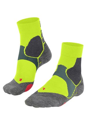 Grüne und graue Sportsocken mit einem geribbelten Bündchen, die mit kräftigen Farbmuster, strukturiertem Gewebe und roten Akzenten an Zehen und Ferse versehen sind.