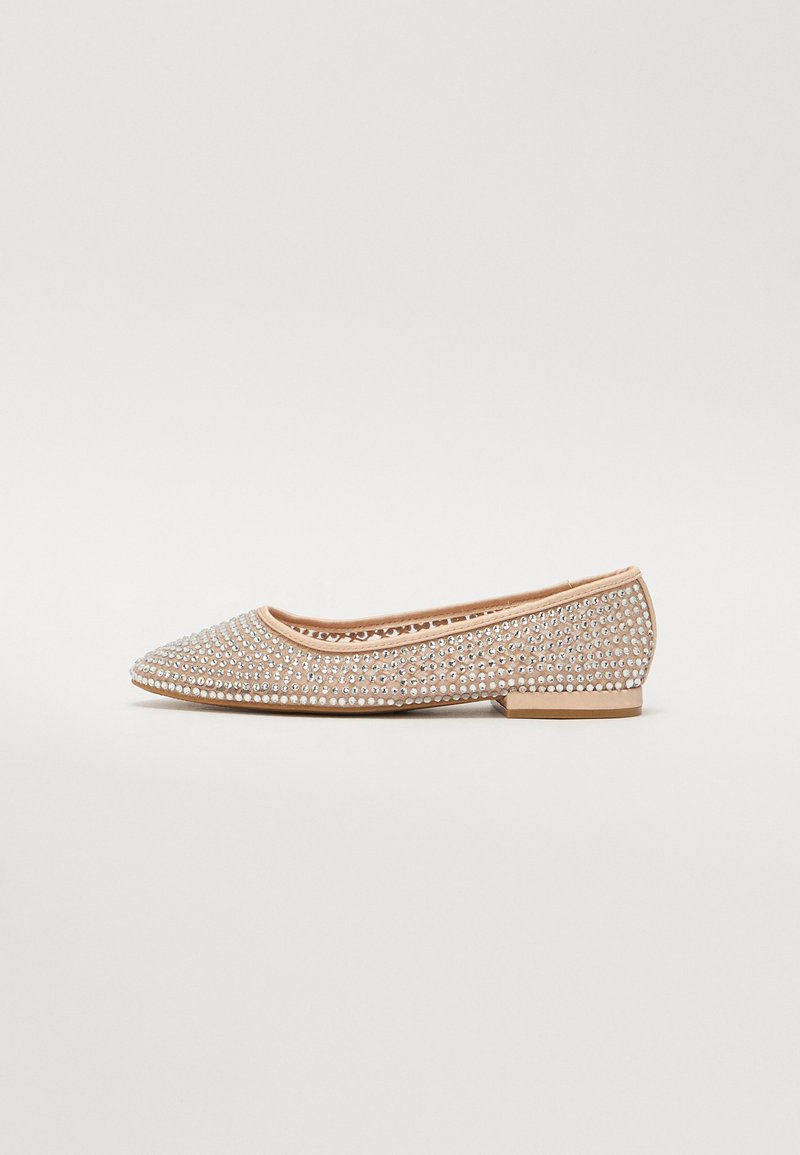 Décolleté con punta, ricoperte di strass argento su una base di tessuto beige, caratterizzate da un tacco basso e solido.