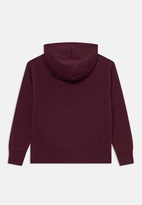 Sweat à capuche bourgogne avec une texture douce, à manches longues et une grande capuche. Présente un ourlet droit et des poignets côtelés sans détails supplémentaires.