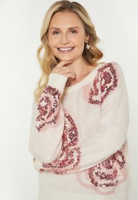 Hele roosa soe sviiter on valmistatud pehmest kangast, millel on üle mõõtu roosi mustrid, millel on roosa kuldne sädelevus varrukatel. Ribidega mansetid ja allserv.