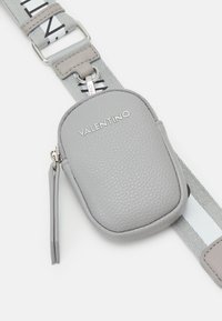 Bolsita de cuero gris con superficie texturizada, cierre de cremallera y una correa con una franja de contraste. Logo "VALENTINO" mostrado en el frente.