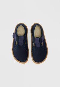 Σκούρα μπλε πάνινα παπούτσια με λαστιχένιες σόλες, με λουράκι βέλκρο, κομμένες πλευρές και υφή σε ύφασμα. Λείο εσωτερικό φόδρα.