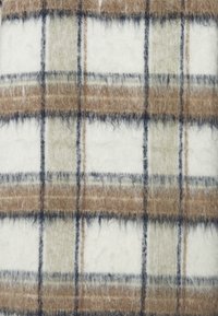 Soft fuzzy fabric with a plaid pattern in beige, brown, black, and white colors.