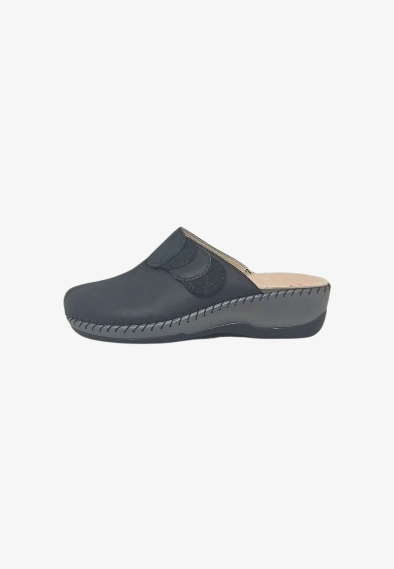 Zoccolo nero in pelle senza lacci con cinturino in velcro regolabile e suola imbottita, progettato per il comfort e la facilità di utilizzo.