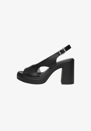 Sandale slingback en cuir noir à bout ouvert, avec bride à boucle ajustable, talon bloc épais et haut, et semelle plateforme.