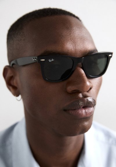 Черни слънчеви очила Ray-Ban с правоъгълни лещи, с дебела рамка и подписан логотип отстрани. Гладък пластмасов материал.