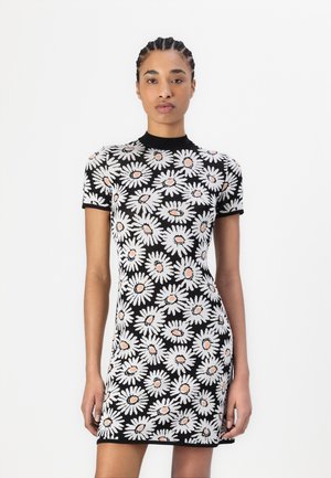Knit dress featuring a black base with white daisies and pink centers, short sleeves, and a round neckline, presenting a fitted silhouette.