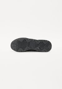 Schwarze Schuhsohle mit einem strukturierten Profilmuster, das erhabene geometrische Formen und gesprenkelte Details für verbesserten Halt und Langlebigkeit aufweist.