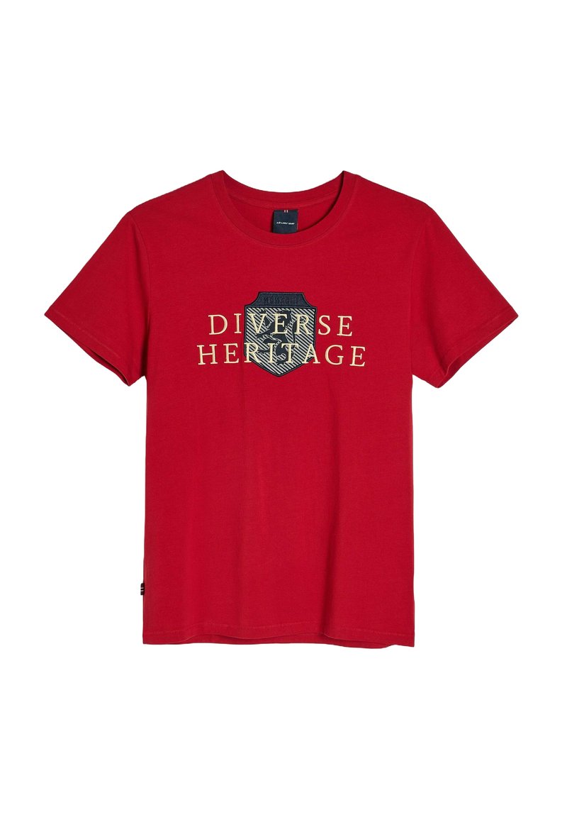 Czerwona bawełniana koszulka z okrągłym dekoltem i krótkimi rękawami. Na przodzie znajduje się wzór przedstawiający tarczę z napisem "Różnorodne Dziedzictwo" w kolorze złotym.
