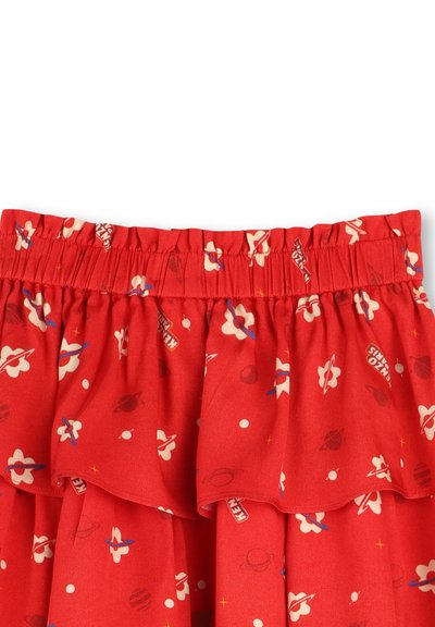 Rode rok met patroon, elastische tailleband en ruches aan de onderrand. Bevat bloemen, planeten en sterren in contrasterende kleuren op de stof.