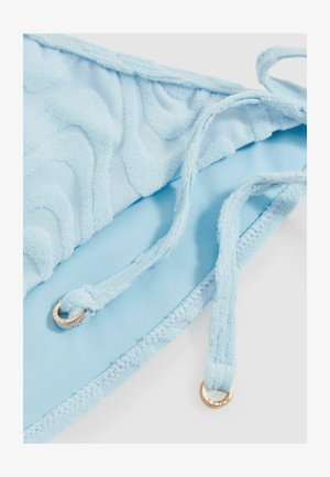 Šviesiai mėlynos bikini viršus su tekstūriniu bangų raštu, reguliuojamomis petnešėlėmis ir aukso spalvos aksesuarais. Minkšta, puri medžiaga.