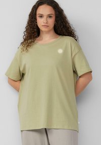 Hellgrünes Baumwoll-T-Shirt mit kurzen Ärmeln, lässiger Passform, Rundhalsausschnitt und einem kleinen Sonnenmotiv auf der linken Brust. Weiche Textur, einfaches Design.