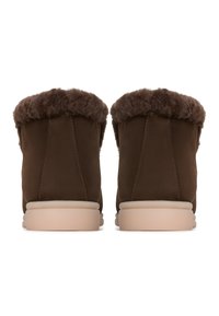 Bottes de cheville en daim marron avec une douce bordure en fourrure texturée en haut et une semelle en caoutchouc de couleur claire. Design simple et fonctionnel.