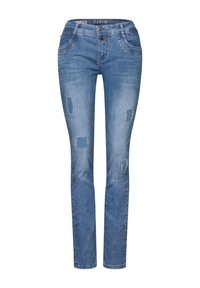 Jeans de mezclilla azul claro con un corte ajustado, que cuentan con dos bolsillos frontales y parches desgastados en formas variadas en las piernas. Cierre de doble botón.