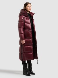 Bordeauxrode gewatteerde lange jas met capuchon, voorzien van een ritssluiting aan de voorkant, twee zijzakken en een geribbelde textuur. Draagt over zwarte kleding en laarzen.