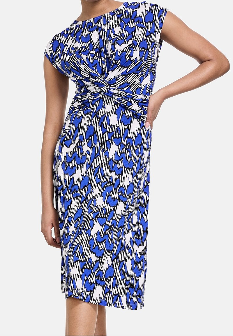 Robe sans manches mi-longue avec imprimé animal abstrait bleu, noir et blanc, avec un détail de nœud torsadé à la taille.