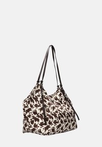 Bolso de hombro de lona con un patrón de vaca en tonos marrón y beige. Presenta dos largas correas marrones y detalles fruncidos en la parte superior.