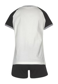 T-Shirt mit kurzen Ärmeln, bestehend aus einem weißen Oberteil mit schwarzen Raglanärmeln und grauen Akzenten am Hals. Kombiniert mit schwarzen Shorts, beide aus weichem Stoff.
