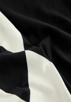 Material de bumbac alb-negru cu un model diagonal în formă de diamant, având o textură netedă și o cădere moale.