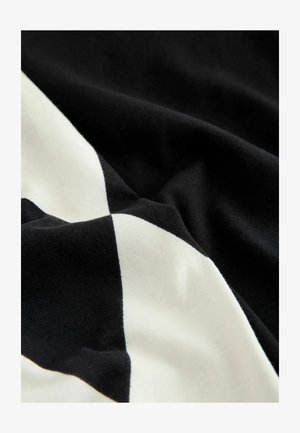 Material de bumbac alb-negru cu un model diagonal în formă de diamant, având o textură netedă și o cădere moale.