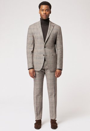 Gray plaid suit with a tailored fit, featuring a two-button blazer and flat-front trousers. Worn over a black turtleneck and brown shoes.