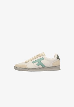 Sneaker beige basse con punta traforata, logo laterale verde, dettagli in suede e suola grigia, mostrata di profilo laterale.