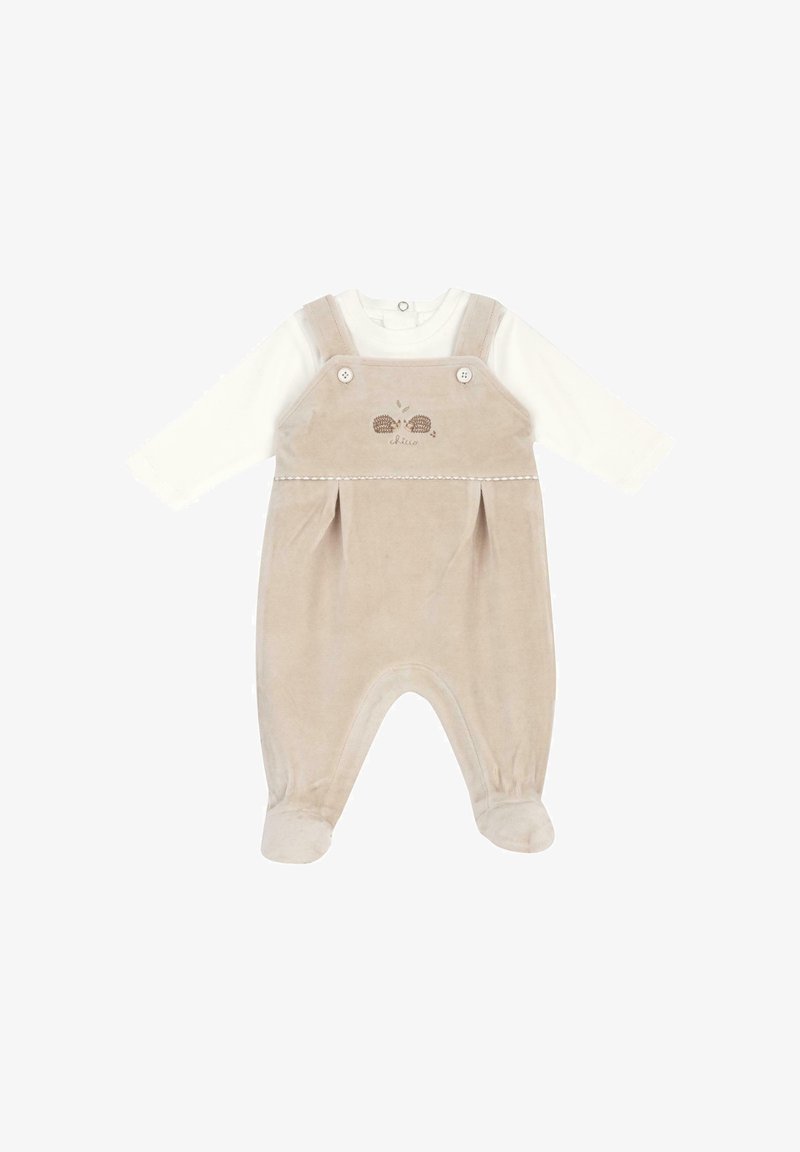Barboteuse bébé beige douce avec manches longues blanches, pieds attachés, bretelles boutonnées et petite broderie de hérisson sur la poitrine.