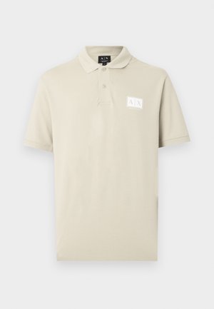 Beige kortærmet polo skjorte med to knapper og et lille "A|X Armani Exchange"-logo på venstre bryst.