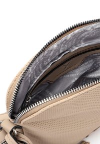 Borsa a tracolla in pelle beige con texture perforata, cerniera argentata e fodera in tessuto grigio a contrasto con un motivo sottile. Tasche interne visibili.