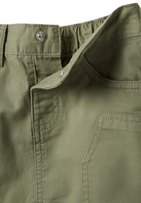 Pantaloni in cotone verde oliva con vita elasticizzata, tasca anteriore e dettaglio con bottone in metallo, cuciture visibili e texture liscia.