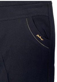 Black pants with a zippered pocket accented by a gold logo. Features a smooth texture and slim design with decorative stitching.