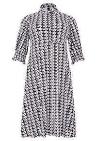 Schwarzes und weißes gemustertes Hemdkleid mit Knopfleiste, kurzen Puffärmeln und Kragen. Der Stoff hat ein geometrisches Design und eine glatte Textur.