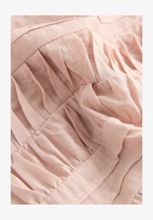 Svetloružová látka so zhromaždenou textúrou; obsahuje jemné záhyby a viditeľné šitie, čo zvýrazňuje hladký, jemný povrch.