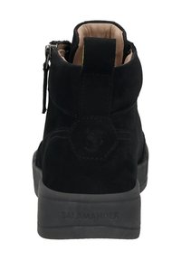 Schwarze Wildleder-Ankle-Boots mit einem gepolsterten, tanfarbenen Innenfutter, einem Reißverschluss hinten und einer strukturierten, schwarzen Gummisohle, die mit "SALAMANDER" geprägt ist.