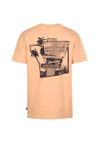 Perzikkleurig katoenen T-shirt met een print op de rug van palmbomen en vintage reclame in donkerblauw. Korte mouwen en een ronde hals.