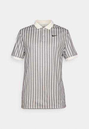 Ribaga polo särk koore ja tumesinises, millel on nööbitav krae, lühikesed varrukad ja väike must Nike logo rinnal.