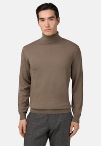 Hnedý rolák so žebrovanou textúrou, s priliehavým strihom a dlhými rukávmi, v kombinácii so šedými károvanými nohavicami.