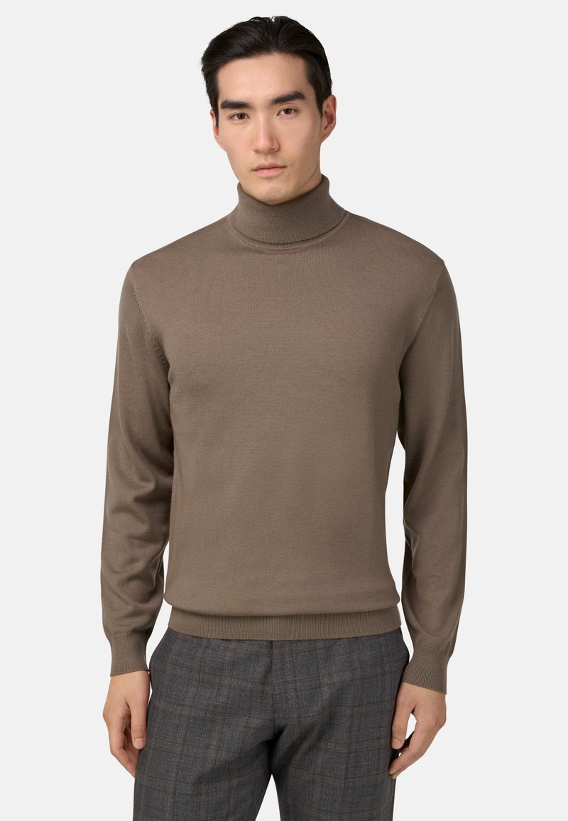 Hnedý rolák so žebrovanou textúrou, s priliehavým strihom a dlhými rukávmi, v kombinácii so šedými károvanými nohavicami.