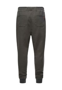 Pantalones de chándal grises con cintura elástica, dos bolsillos traseros, piernas ajustadas y puños acanalados. Fabricados con un material suave y texturizado.