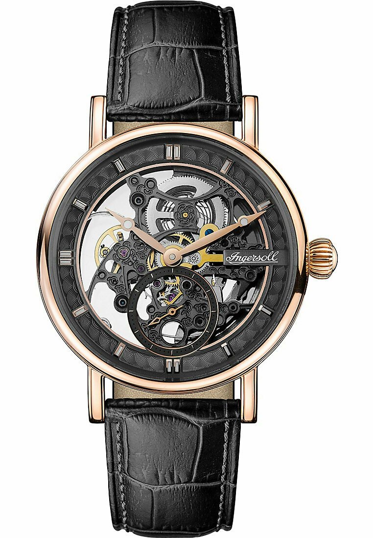 Mekanisk klocka med en transparent skelettskiva. Fall i roséguld-ton, svart läderarmband med krokodilprägling. Anmärkningsvärda intrikata kugghjul.