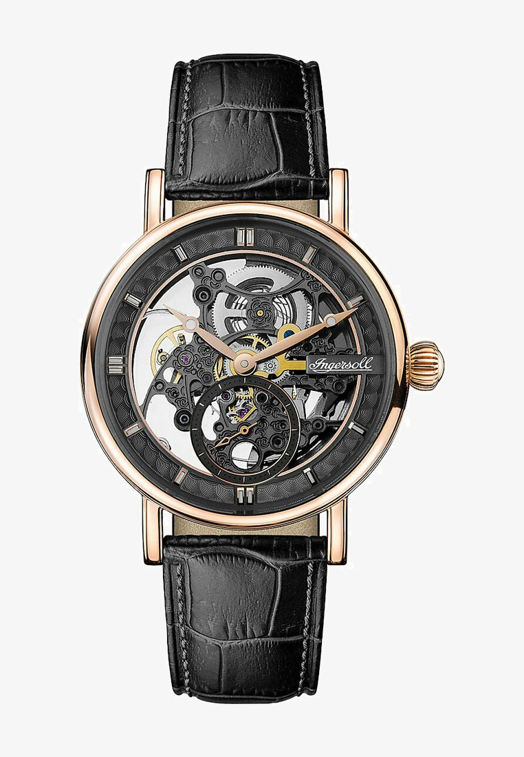 Mechanisch horloge met een transparante skeletdial. Roze goudkleurige kast, zwarte leren band met een krokodillenembossing. Opvallende ingewikkelde tandwielen.