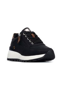 Zapatilla negra con parte superior texturizada, suela blanca de contraste, ojales de metal y un zipper lateral. Presenta acentos de cuero marrón y una puntera de goma.