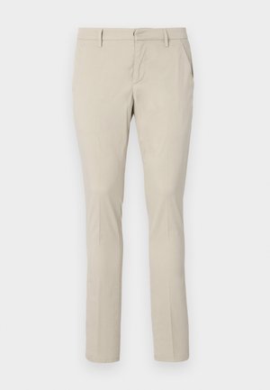 Chinos beige avec une coupe droite, dotés de poches latérales et d'une texture de tissu lisse. Aucuns motifs visibles ni détails métalliques.