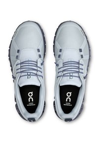 Light blue waterproof athletic shoes with a textured upper, reflective accents, and dark rubber soles. Features elastic laces and logo on insoles.
