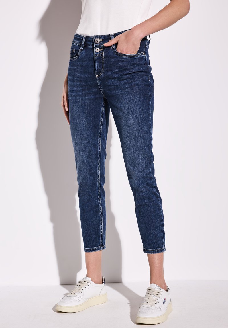 Mörkblå denimjeans med en slim fit-design, som har en midja i medelhöjd, två framfickor och en croppad längd ovanför anklarna.