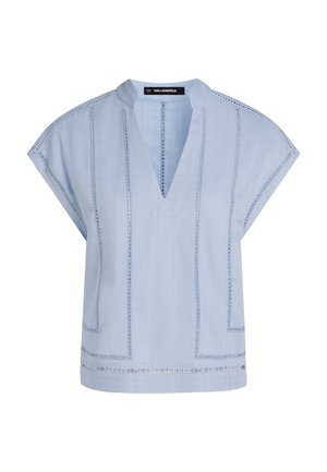 Bluza albastru deschis cu decolteu în V, mâneci scurte și cusături decorative. Prezintă o formă dreptunghiulară și modele texturate ușor vizibile. Cusături orizontale evidente.