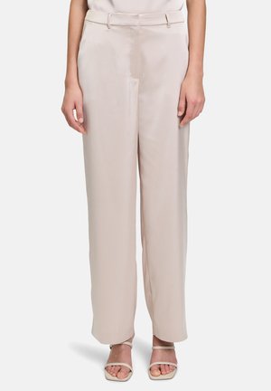 Helle beige, hochgeschnittene Hose mit glatter Satin-Oberfläche, tailliertem Schnitt und weitem Bein, kombiniert mit minimalistischen Riemchensandalen.