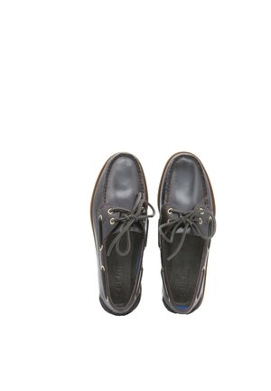 Coppia di scarpe da barca in pelle marrone scuro con lacci, occhielli dorati e suole in gomma, viste dall'alto su uno sfondo bianco.