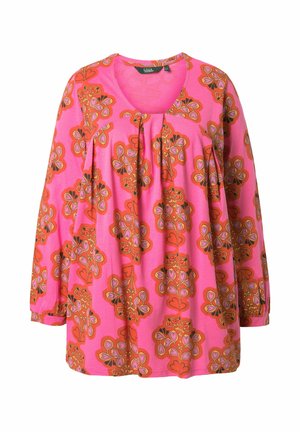 Růžová blůza s dlouhým rukávem s oranžovými a červenými květinovými vzory, kulatým výstřihem a záhyby pod límečkem.